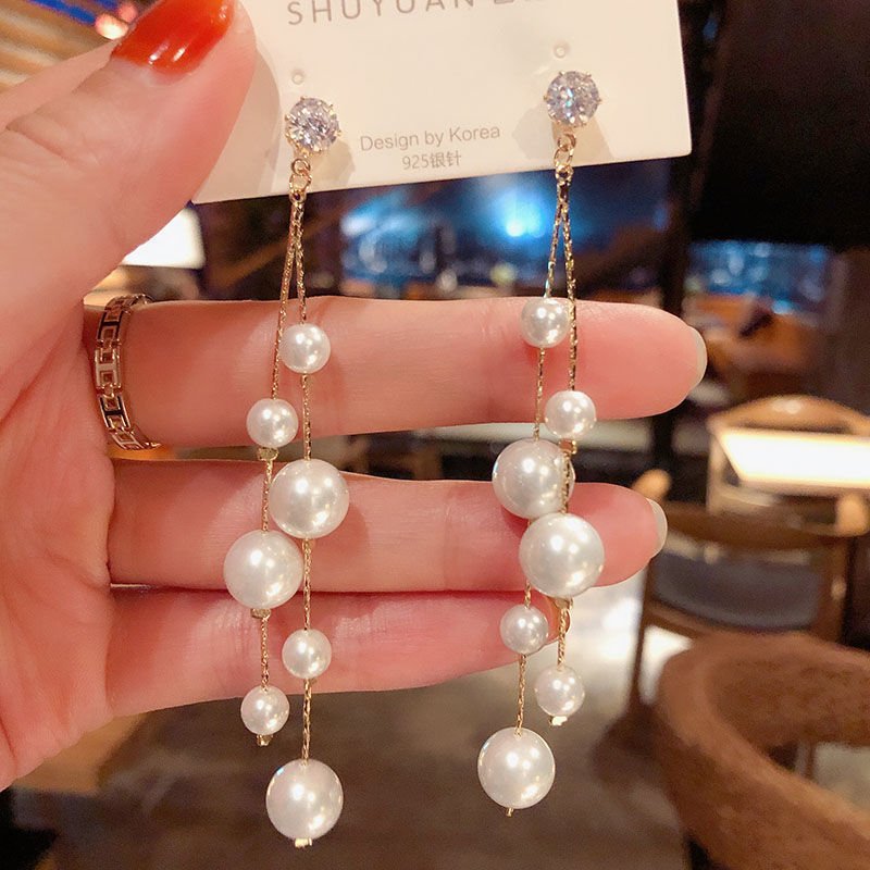 Long gold-tone chain earrings with white pearl-look beads